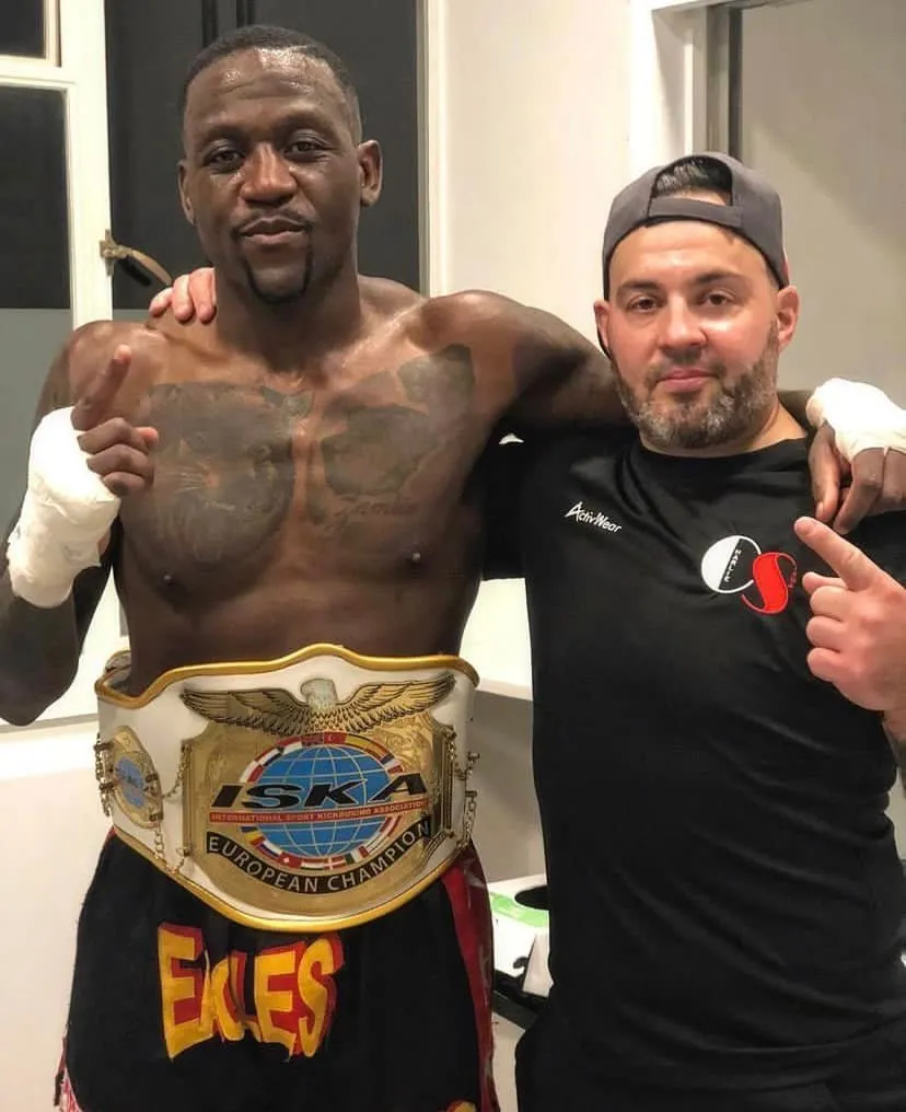 Fighter and coach with a championship belt