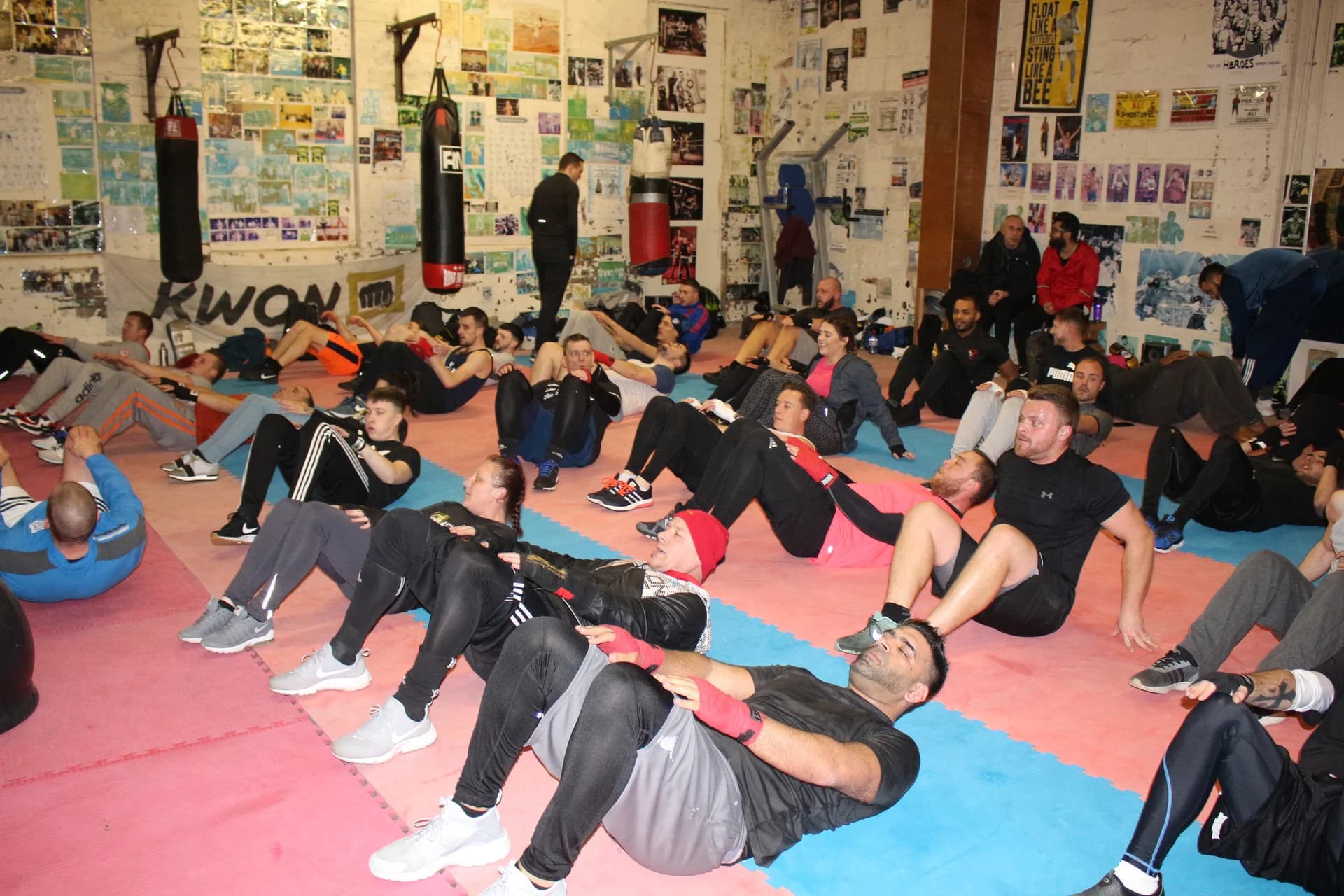 A group working through seated core exercises on the mats at UFCC