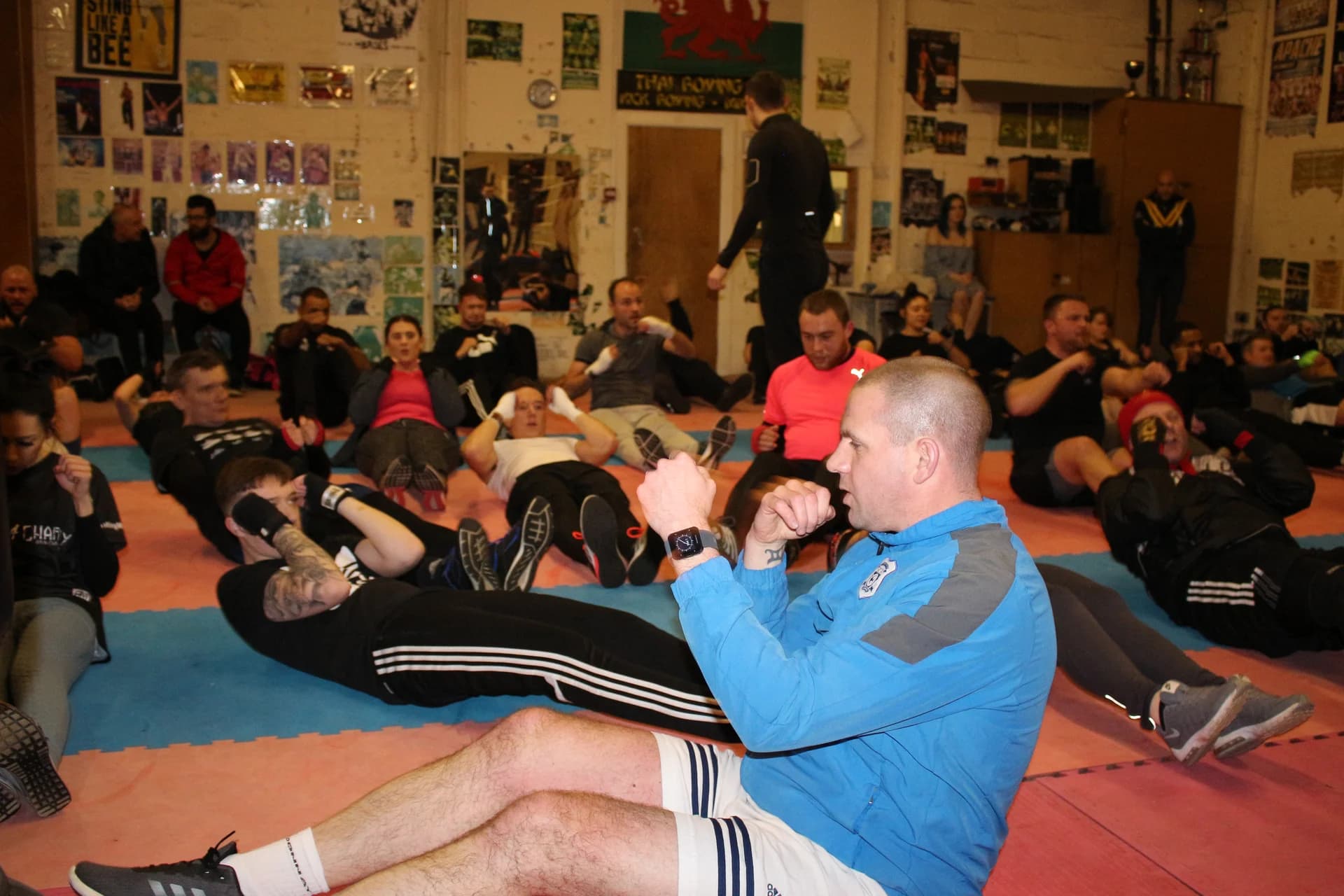 Boxing participants doing seated exercises with their hands held in guard at UFCC