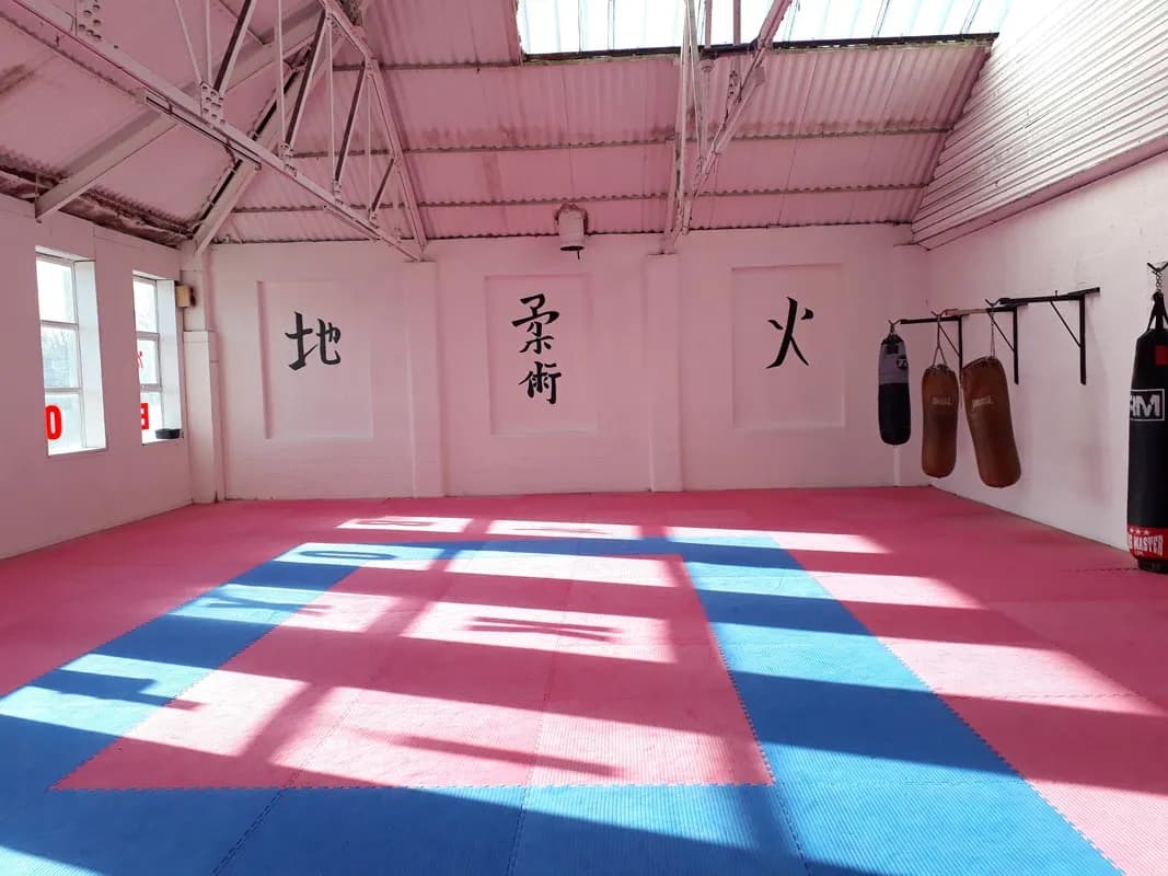 The dojo at UFCC, with matted floor and punch bags