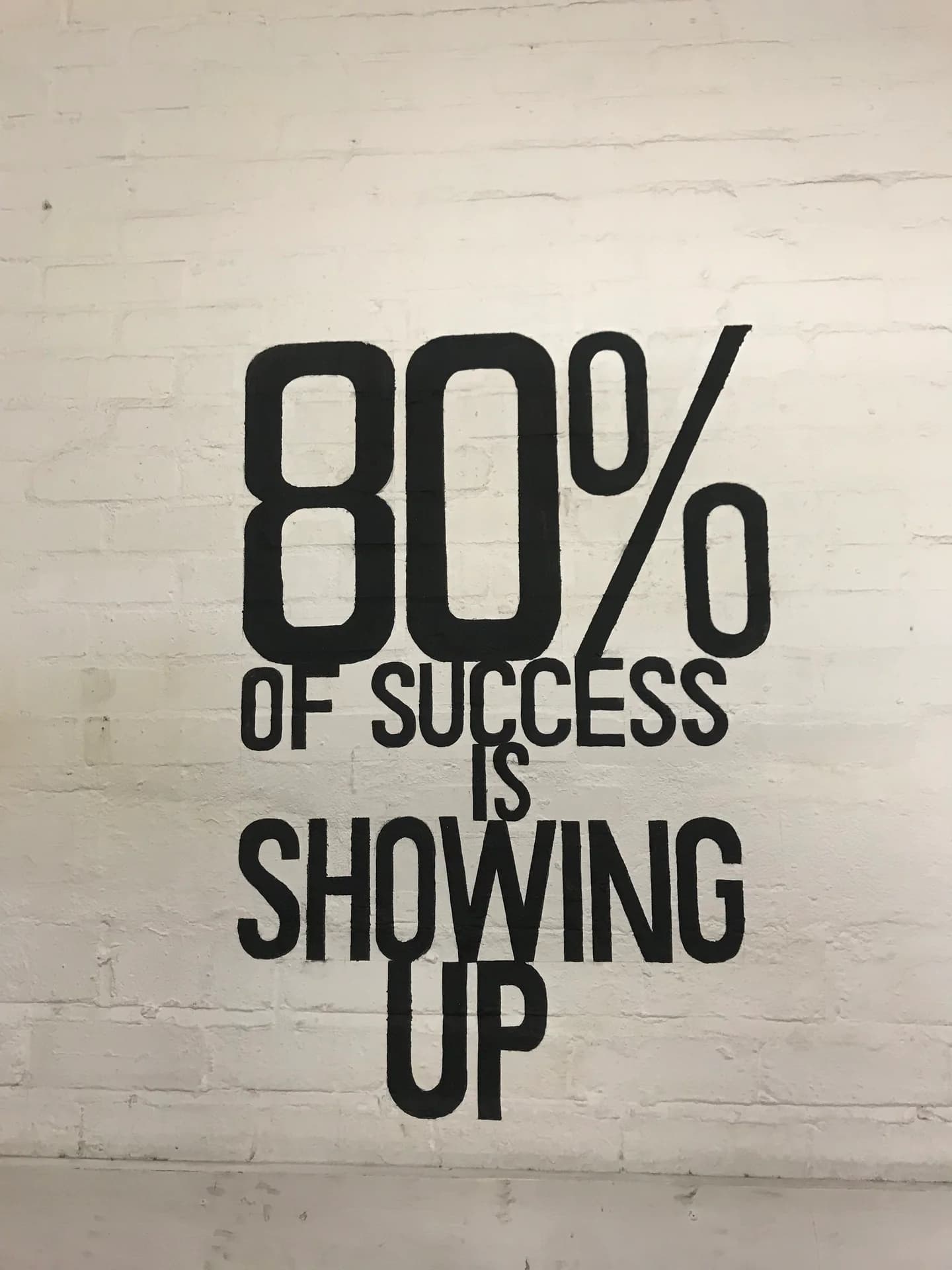 The gym wall reads: 80% of success is showing up